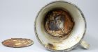 Auschwitz museum staff discover jewelry hidden in mug for decades