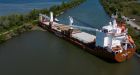 Tugboats free grounded cargo ship blocking traffic in St. Lawrence Seaway